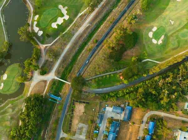 空中风景无人俯冲美丽的绿色高尔夫球场日落时高角度风景 — 图库照片