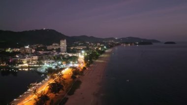 Karon şehrinin gece hava görüntüsü deniz yüzeyinin üstünde gün batımı, Karon sahilinde, Phuket Tayland 'da hava aracı uçuşu.