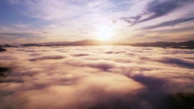 Yüksek açılı drone manzaralı yaz mevsiminde dağların üzerinden sis manzarası, doğanın video sahnesini yaratmak için güzel gündoğumu bulutları. 4K Yüksek kaliteli görüntü