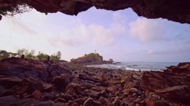 Lanta Ulusal Parkı, Krabi Tayland 'daki kayadaki deniz feneri. Sahilden önplanda taşlar ve kayalar, yaz havası, bulutlu mavi gökyüzü