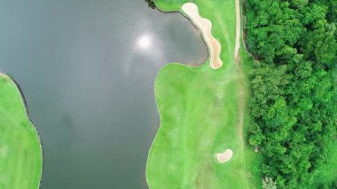 Golf sahasının havadan görünüşü yeşil çimenleri ve ağaçları golf sahasına koyuyor ve yeşil üst manzarayı yaz güneşli günlerinde golf sahalarının üzerine koyuyor.