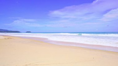 Yaz mevsiminde tropikal deniz manzarası Püket Tayland 'da Karon sahilinde kumlu kıyıya vuran dalgalar yaz mevsiminde güzel deniz, mavi gökyüzü arka planı