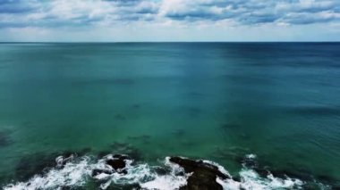 Deniz yüzeyi dalgalarının okyanusa köpüren ve sıçrayan havadan görüntüsü. Sunny Day yaz arkaplanı Yüksek kaliteli görüntüler 4-K