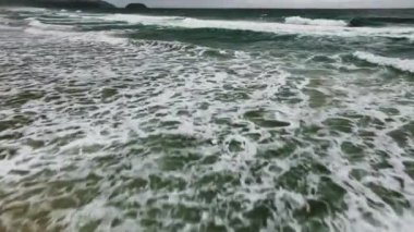 Havadan bakıldığında karanlık deniz yüzeyi, okyanusa çarpan inanılmaz dalgalar, karanlık deniz doğası arka planı.