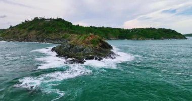 Karanlık bir denizde, deniz yüzeyindeki kayalara vuran dalgalar, kayalara çarpan inanılmaz deniz dalgaları.