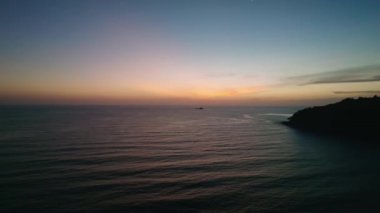 Renkli gün batımı ya da deniz yüzeyinde gün doğumu, açık denizin üzerinde uçan hava aracı.