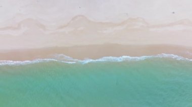 Kumlu sahile vuran dalgaların üst görüntüsü, Deniz Okyanusu arka planı