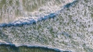 Kumlu sahile vuran dalgaların üst görüntüsü, Deniz Okyanusu arka planı