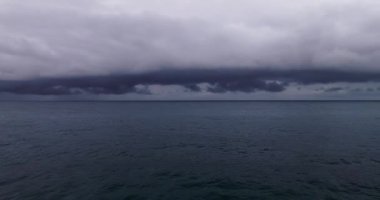 Fırtına bulutları ve denizin üzerindeki yağmur, videoyu geçen kara fırtına bulutları, denizin üzerindeki yüksek kaliteli görüntüler ve arka plan dalgaları.