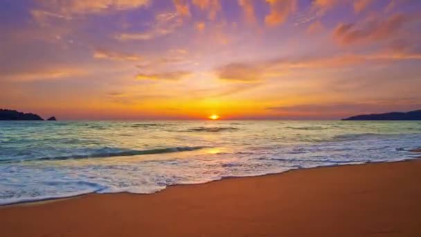 カラフルな光の日没に向かって転がる泡立った波や砂浜の上に日の出 美しい砂浜の美しいゆっくりとした動きの波 美しい空の黄金の太陽 — ストック動画