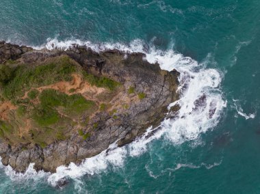 Phuket Tayland 'da dağları olan deniz manzarası yaz mevsiminde açık denizde güzel deniz manzarası dalgalar kıyı kayalarına çarpıyor.