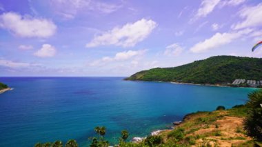 Phuket Adası üzerinde paragliding sporu, arka planda inanılmaz deniz kıyısı tropikal denizi, Phuket Adası 'nın batı kıyısında aşırı aktivite, kıyıda paragliding noktası, havada uçan kumaş kanat.