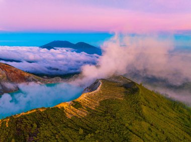 Gündoğumunda turkuaz sülfür gölüyle Kawah Ijen volkanında kayalıkların muhteşem hava manzarası. Endonezya, Doğu Java 'da doğa manzarası. Doğal manzara arka planı