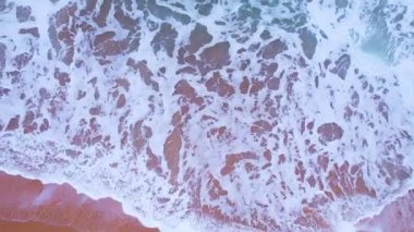 Dalgalar deniz suyu yüzeyi yüksek kaliteli video görüntüsü kuş bakışı dron üst görüntü dalgaları kumsal sahili, doğa okyanus sahili arka planı.
