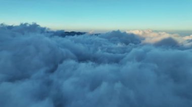 Sis üzerinde uçan hava görüntüsü, hatalı kamera görüntüsü. Gün batımında ya da gün doğumunda sisli hava, yukarıdan inanılmaz bir manzara. Kuşların bakış açısı doğa bulutları manzara arkaplanı