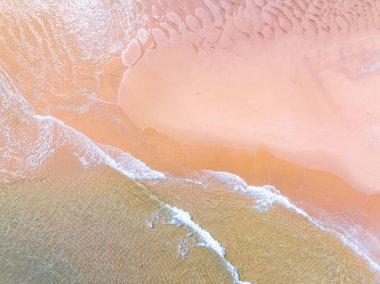 Kumlu sahile vuran dalgalar, arka planda deniz dalgaları