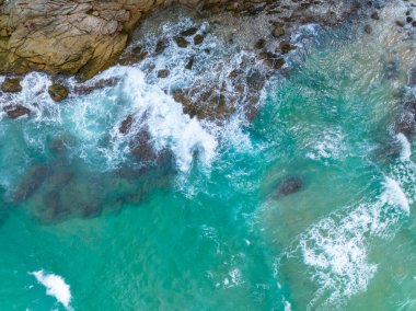 Phuket Tayland 'da dağları olan deniz manzarası yaz mevsiminde açık denizde güzel deniz manzarası dalgalar kıyı kayalarına çarpıyor.