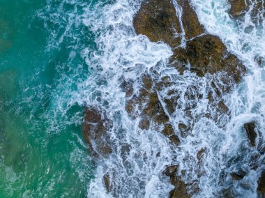 Phuket Tayland 'da dağları olan deniz manzarası yaz mevsiminde açık denizde güzel deniz manzarası dalgalar kıyı kayalarına çarpıyor.