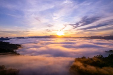 Güneşin doğuşu ya da batışı dağların tepelerinde sisle kaplı, hava manzaralı insansız hava aracı güzel renkli bir arka plan çekti.