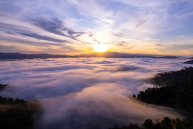 Güneşin doğuşu ya da batışı dağların tepelerinde sisle kaplı, hava manzaralı insansız hava aracı güzel renkli bir arka plan çekti.