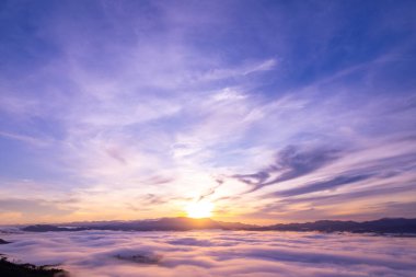 Güneşin doğuşu ya da batışı dağların tepelerinde sisle kaplı, hava manzaralı insansız hava aracı güzel renkli bir arka plan çekti.