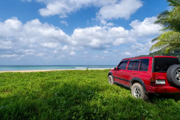 Red SUV 4x4 car on the mountain with Summer sea and blue sky background,Copy space for summer text and travel transportation background.