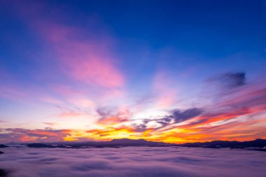 Güneşin doğuşu ya da batışı dağların tepelerinde sisle kaplı, hava manzaralı insansız hava aracı güzel renkli bir arka plan çekti.