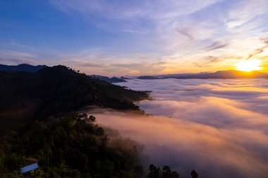 Güneşin doğuşu ya da batışı dağların tepelerinde sisle kaplı, hava manzaralı insansız hava aracı güzel renkli bir arka plan çekti.
