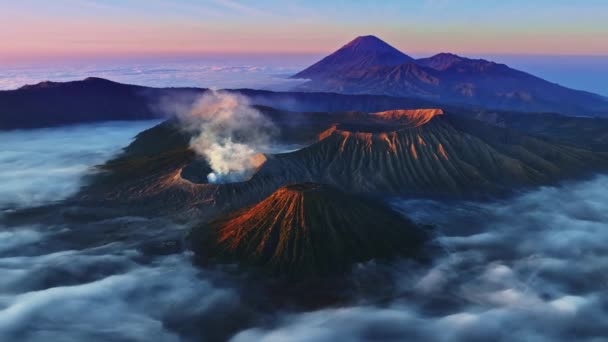 ブロモンテンガーセメル国立公園 東ジャワ インドネシア ランドスケープの背景にある山の日の出や日没の間の素晴らしいブロモ火山 — ストック動画