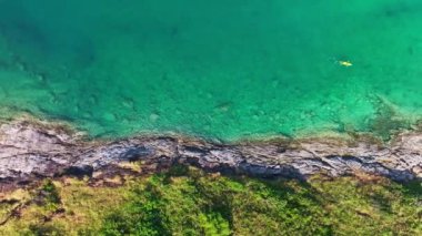 Yaz mevsiminde deniz kenarındaki kayaların insansız hava aracı kamerası, güzel deniz yüzeyi, Phuket Adası Tayland 'daki kayalara çarpan inanılmaz deniz dalgaları, 4K' lık hava aracı görüntüsü.