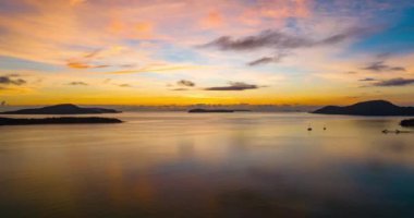 Hava manzaralı Drone Yüksek açılı görüntüsü, Phuket Tayland 'ın su yüzeyinde yansıması olan güneşin deniz üzerinde yükseliş görüntüsü, Güzel günbatımı veya gündoğumu gökyüzü arkaplanı, Timelapse gökyüzü bulutları