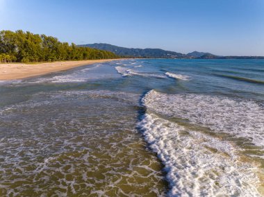 Kumlu sahile çarpan dalgaların hava görüntüsü, deniz yüzeyi okyanus dalgaları arka planı, plaj arka planı.