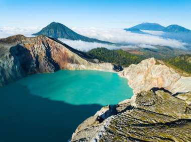 Kawah Ijen volkanındaki kayalıkların gündoğumunda turkuaz sülfür su gölü manzarası. Doğu Java, Endonezya 'daki doğa manzarası. Doğal manzara.