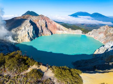 Kawah Ijen volkanındaki kayalıkların gündoğumunda turkuaz sülfür su gölü manzarası. Doğu Java, Endonezya 'daki doğa manzarası. Doğal manzara.