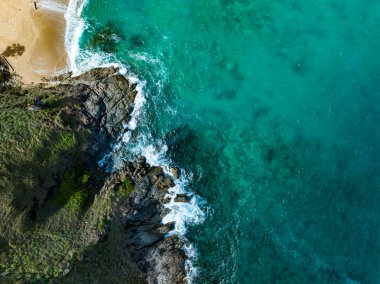 Kuş bakışı deniz kıyısı. Büyük dalgalar kayalıklara çarpıyor. Güneşli yaz arka planında güzel dalgalar deniz yüzeyinde inanılmaz deniz manzarası deniz manzarası manzarası