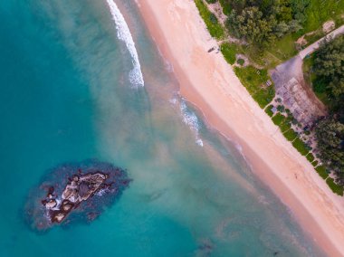 Kuş bakışı deniz kıyısı ve kumlu kıyıya dalga çarpıyor. Güneşli yaz arka planında güzel dalgalar deniz yüzeyinde inanılmaz deniz manzarası deniz manzarası manzarası