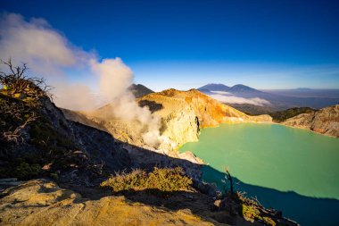 Turkuaz Su Gölü ile Deadwood Yapraksız Ağacı, Güzel doğa manzarası dağı ve Kawah Ijen volkanı, Doğu Java, Endonezya 'da yeşil göl