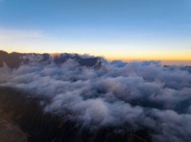 Tropikal yağmur ormanlarındaki dalgalı sis dalgaları, bulutların üzerindeki kuş bakışı görüntüler Endonezya 'daki bulutlar ve dağ zirveleriyle dolu doğa arka planı.