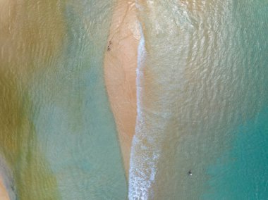 Kumlu sahile çarpan dalgaların hava görüntüsü, deniz yüzeyi okyanus dalgaları arka planı, plaj arka planı.