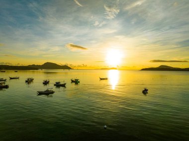 İnanılmaz gün batımı ya da deniz manzarasında gün doğumu gökyüzü, doğanın güzel rengarenk ışığı denizde tekneler, insansız hava aracı kamerası, tepeden aşağı deniz manzarası.