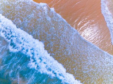 Kumlu sahile çarpan dalgaların hava görüntüsü, deniz yüzeyi okyanus dalgaları arka planı, plaj arka planı.