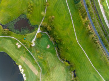 Yeşil golf sahasının hava manzarası spor arka planı ve seyahat için yukarıdan aşağıya görüntü, inanılmaz yeşil doğa manzarası.