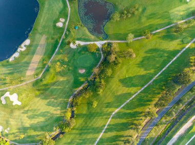 Yeşil golf sahasının hava manzarası spor arka planı ve seyahat için yukarıdan aşağıya görüntü, inanılmaz yeşil doğa manzarası.