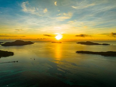 İnanılmaz gün batımı ya da deniz manzarasında gün doğumu gökyüzü, doğanın güzel rengarenk ışığı denizde tekneler, insansız hava aracı kamerası, tepeden aşağı deniz manzarası.
