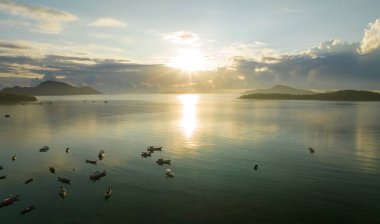 İnanılmaz gün batımı ya da deniz manzarasında gün doğumu gökyüzü, doğanın güzel rengarenk ışığı denizde tekneler, insansız hava aracı kamerası, tepeden aşağı deniz manzarası.