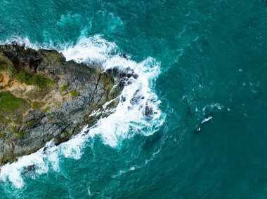 Kuş bakışı deniz kıyısı. Büyük dalgalar kayalıklara çarpıyor. Güneşli yaz arka planında güzel dalgalar deniz yüzeyinde inanılmaz deniz manzarası deniz manzarası manzarası