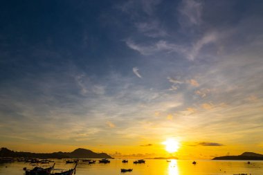 İnanılmaz gün batımı ya da deniz manzarası üzerinde gün doğumu gökyüzü, doğanın güzel renkli ışığı denizdeki tekneler, görkemli doğa manzarası