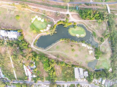 Gün batımında ya da günbatımında güzel yeşil golf sahasının hava görüntüsü, geniş açı üst görüş.