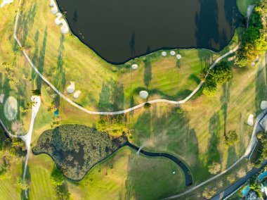 Gün batımında ya da günbatımında güzel yeşil golf sahasının hava görüntüsü, geniş açı üst görüş.