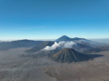 Bromo Volkanı 'ndaki hava manzaralı dağlar güneşli gökyüzü boyunca, Bromo Tengger Semeru Ulusal Parkı' ndaki Penanjakan Güzel Dağları, Doğu Java, Endonezya.